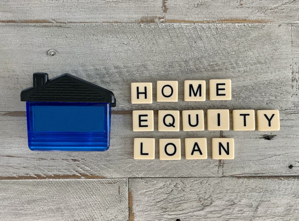 Home Equity Loan flat lay written with tile letters on wooden surface with a house next to it